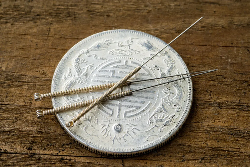 Acupuncture needles on chinese coin